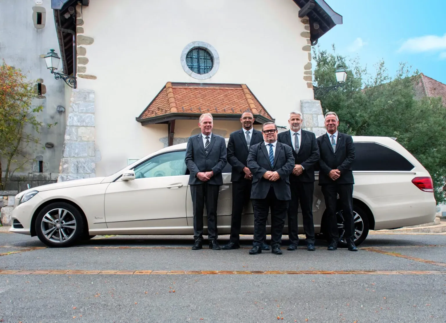 Équipe de porteurs et chauffeur funéraires Golliet avec corbillard.
