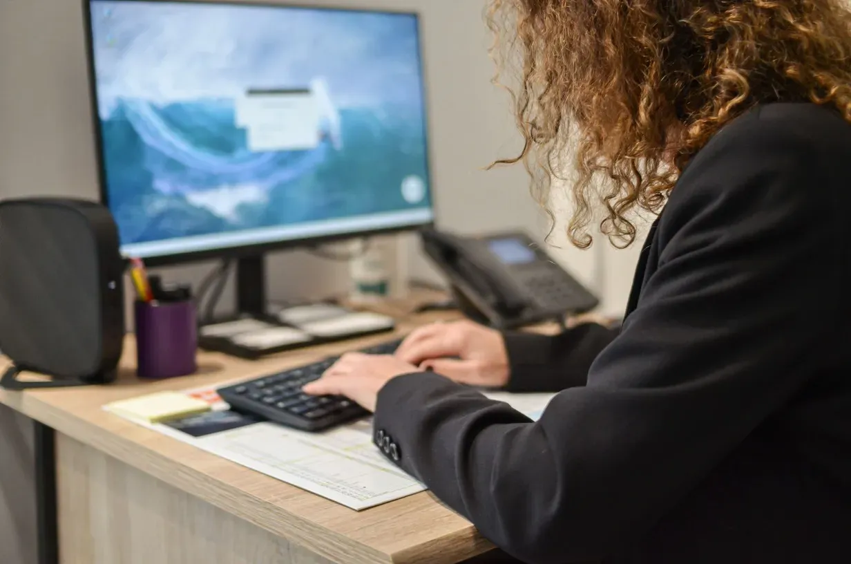 Conseillère funéraire d'Annecy travaillant à son bureau sur un ordinateur.