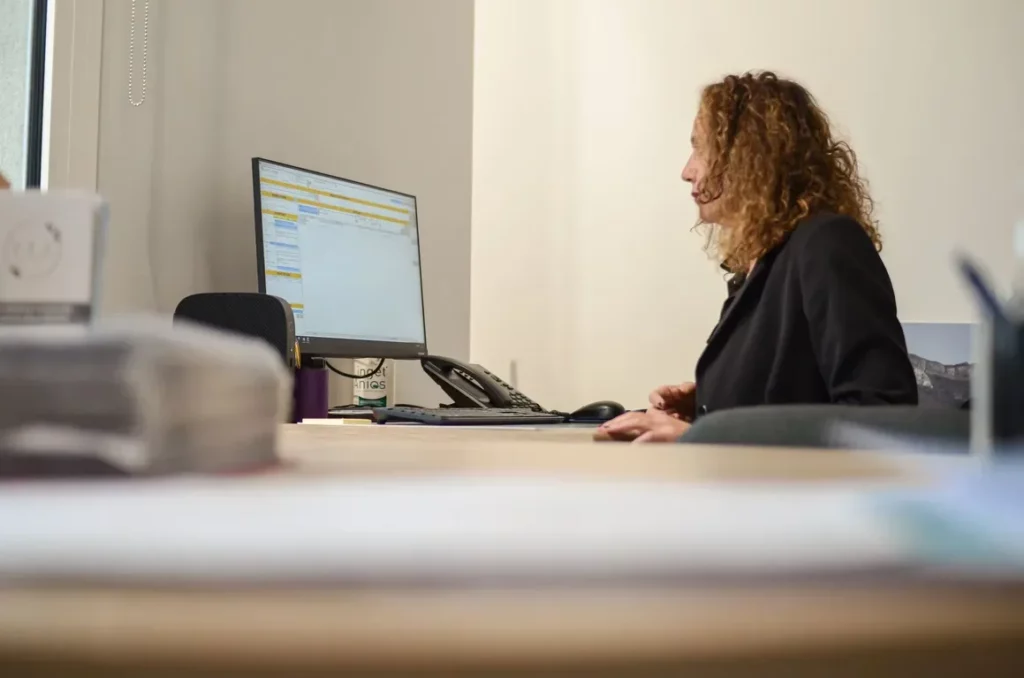 Conseillère funéraire d'Annecy à son bureau devant son ordinateur.